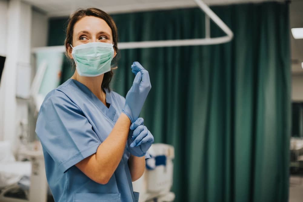 female nurse pulling up glove